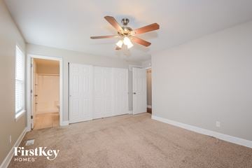 Saint Charles house for rent - a living room with carpet and a ceiling fan