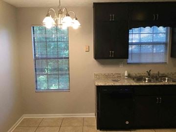 Ellenwood house for rent - A kitchen with black cabinets and a granite countertop.