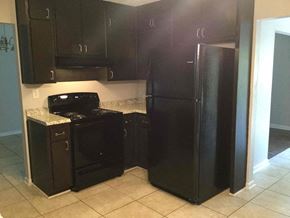 Ellenwood house for rent - A black fridge and oven in a kitchen.