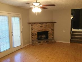 Ellenwood house for rent - A living room with a fireplace and a ceiling fan.