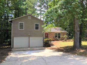 Ellenwood house for rent - A house with a red door is surrounded by trees.