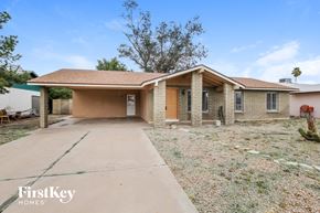 Phoenix house for rent - a small brick house with a driveway and a garage door