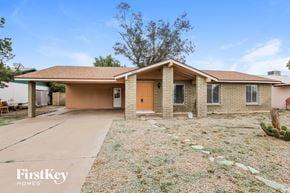 Phoenix house for rent - a small brick house with a driveway and a wooden door