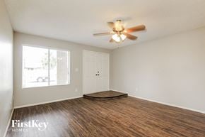 Phoenix house for rent - an empty living room with wood flooring and a ceiling fan
