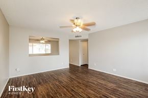 Phoenix house for rent - an empty living room with a ceiling fan and a window