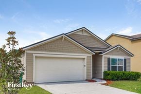 Green Cove Springs house for rent - a beige house with a garage door and a lawn