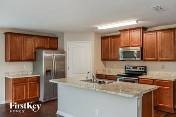 Green Cove Springs house for rent - a kitchen with granite counter tops and wooden cabinets