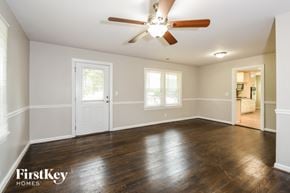 Powder Springs house for rent - an empty living room with wood floors and a ceiling fan