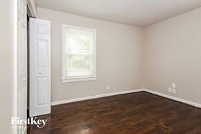 Powder Springs house for rent - the bedroom of a home with wooden floors and a white door