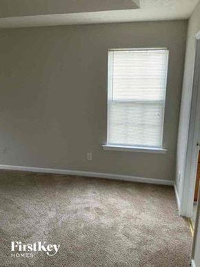Buford house for rent - an empty room with a window and a carpeted floor