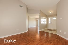 Lakeland house for rent - A spacious room with wooden floors and white walls.