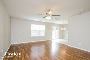 Winston-Salem house for rent - A spacious room with wooden floors and a ceiling fan.
