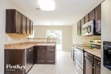 Winston-Salem house for rent - A kitchen with brown cabinets and a black fridge.
