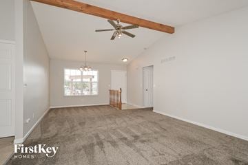 Saint Charles house for rent - a spacious living room with carpet and a ceiling fan