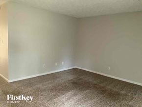 Stone Mountain house for rent - an empty living room with carpet and white walls