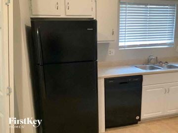 Stone Mountain house for rent - a kitchen with a black refrigerator and a sink