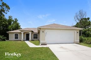 Lehigh Acres house for rent - a beige house with a garage door and a lawn