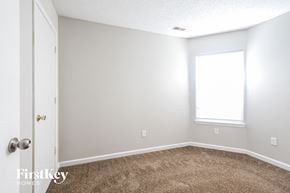 Indianapolis house for rent - a bedroom with a carpeted floor and a window
