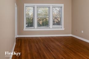Chicago house for rent - a living room with wood floors and a large window