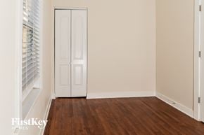 Chicago house for rent - a bedroom with a door and wood floors and a window