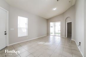 Homestead house for rent - an empty living room with tiled floors and a door to a patio