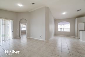 Homestead house for rent - an empty living room with tiled floors and white walls