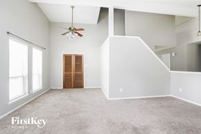 Humble house for rent - A spacious room with a ceiling fan and a door.