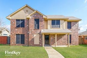 Balch Springs house for rent - A brick house with a porch and a sign that says "FirstKey Homes".