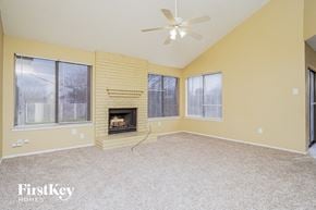 Balch Springs house for rent - A spacious room with a fireplace and a ceiling fan.