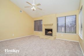 Balch Springs house for rent - A room with a fireplace and a ceiling fan.