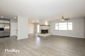 Phoenix house for rent - A spacious living room with a fireplace and a ceiling fan.