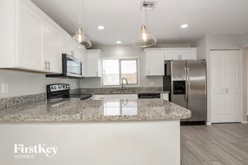 Phoenix house for rent - A kitchen with a granite countertop and a FirstKey Homes logo.