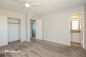 Phoenix house for rent - A spacious room with a carpeted floor and a ceiling fan.