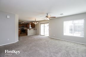 San Tan Valley house for rent - A spacious living room with a ceiling fan and a large window.