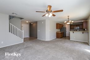 San Tan Valley house for rent - A spacious living room with a ceiling fan and a kitchen area in the background.