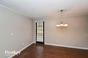 Douglasville house for rent - an empty living room with a window and a chandelier