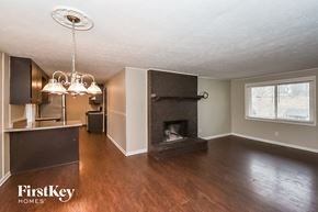 Douglasville house for rent - an empty living room with a fireplace and a kitchen