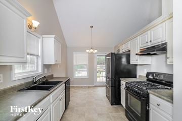 Powder Springs house for rent - a kitchen with black appliances and white cabinets