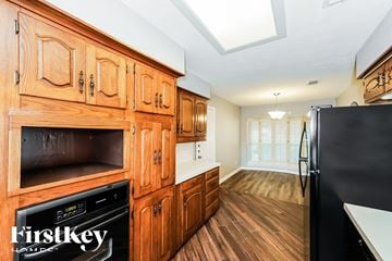 Fort Worth house for rent - A kitchen with wooden cabinets and a black fridge.