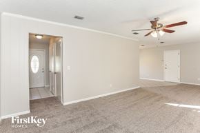Jacksonville house for rent - a living room with carpet and a ceiling fan