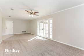 Jacksonville house for rent - an empty living room with a ceiling fan and a window
