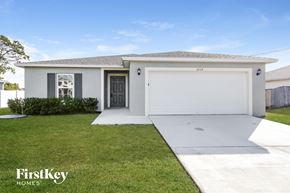 Port St. Lucie house for rent - a white house with a garage door and a lawn