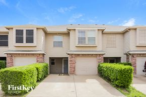 Euless house for rent - a beige house with two garage doors and a driveway