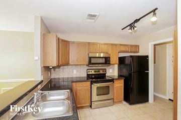 Euless house for rent - a kitchen with stainless steel appliances and wooden cabinets