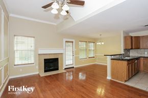 Euless house for rent - an empty living room with a fireplace and a kitchen