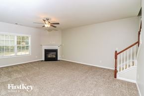 Atlanta house for rent - A living room with a fireplace and a ceiling fan.
