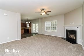 Atlanta house for rent - A spacious living room with a fireplace and a ceiling fan.