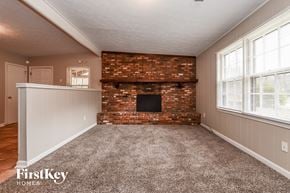Conyers house for rent - A room with a brick fireplace and a carpeted floor.