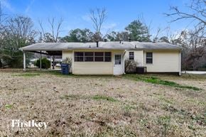 Conyers house for rent - A small house with a porch and a covered area is surrounded by a grassy field.