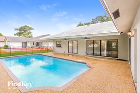 Coral Springs house for rent - A swimming pool in a backyard with a FirstKey Homes logo.